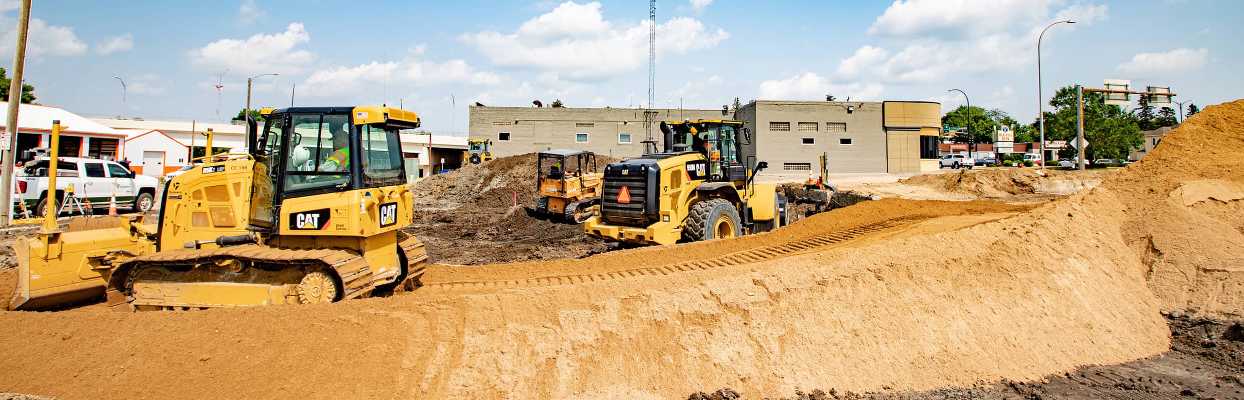 CAT Dozer moving dirt overtop a dirt pile at a commercial construction site.