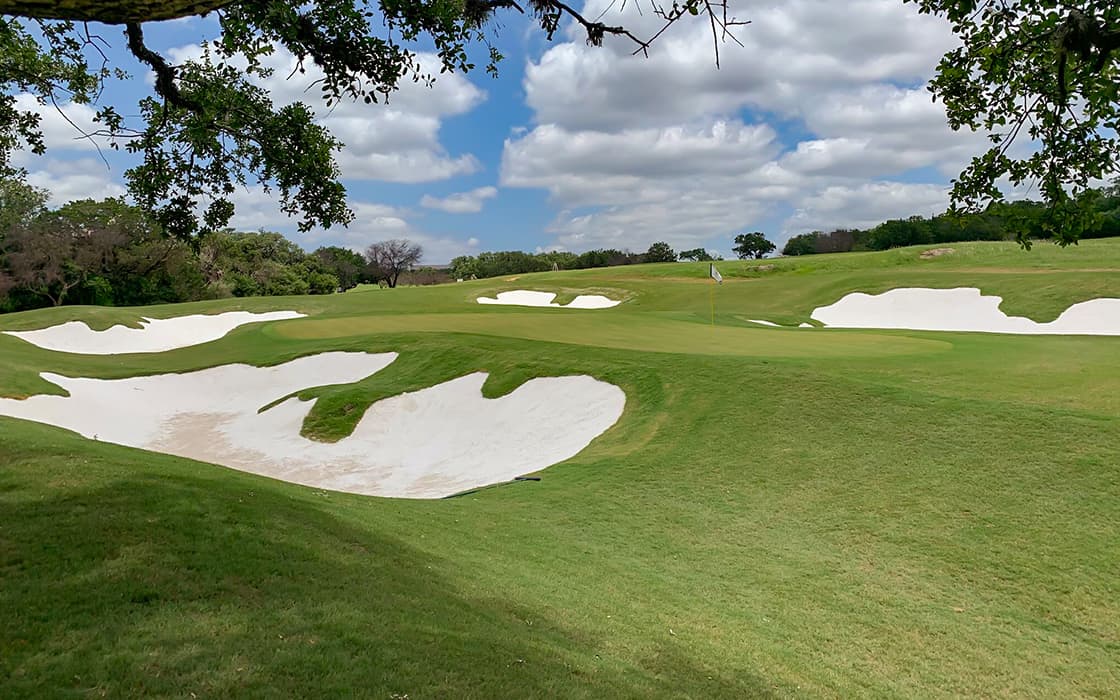 Green golf course with sand pits.