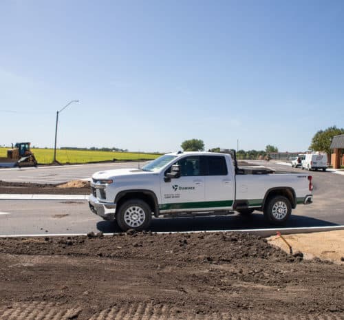 White Duininck pick-up truck parking on top of paved parking lot.