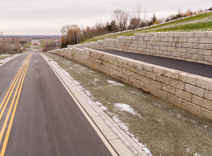 Completed highway paving with retention wall and bike path.