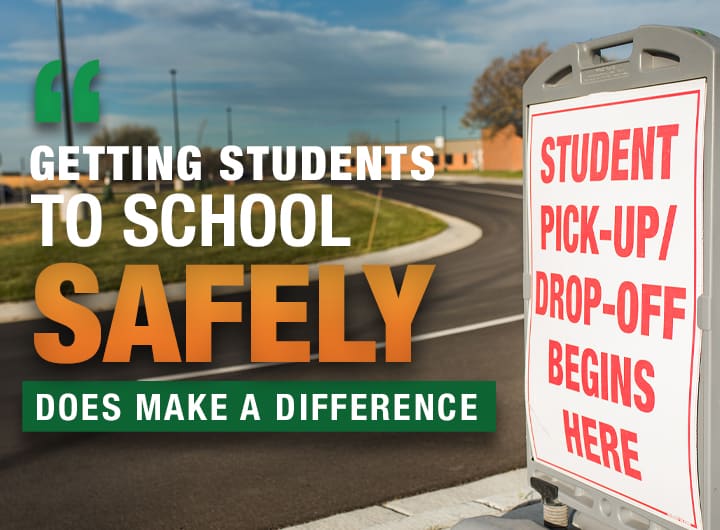 Student pick-up and drop-off sign next to newly paved asphalt parking lot.