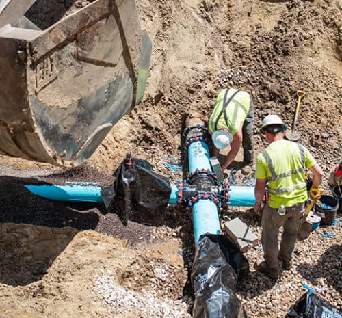 Two men install a new water main.