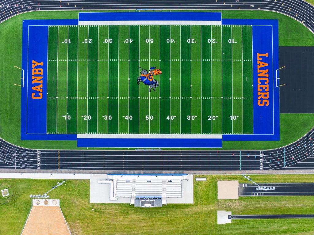Aerial view of a football field with track and bleachers