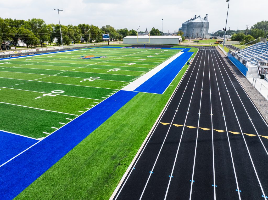 Aerial view of empty football field with track on a sunny day