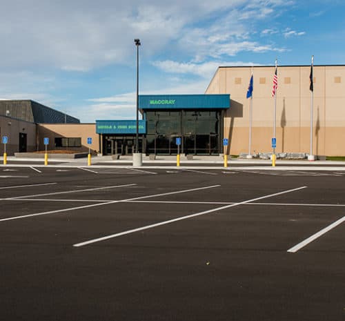 Middle and high school entrance at MACCRAY public school with new asphalt parking lot