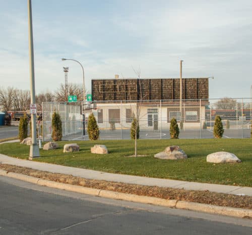 A fenced basketball court with a scoreboard