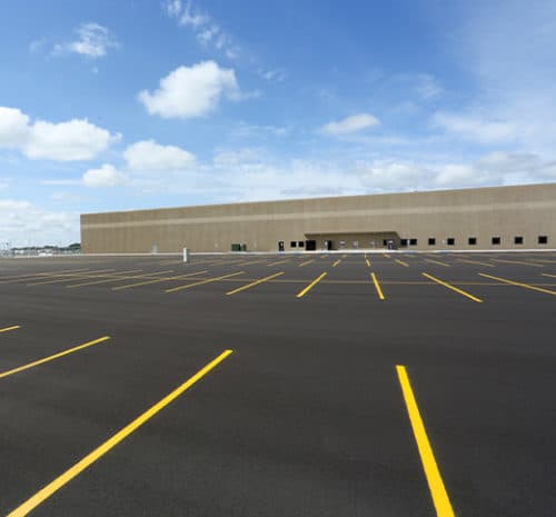 parking lot with large building in the background